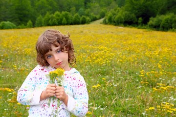 Girl picking flowers in yellow spring meadow