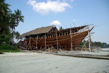 Bateau en teck en construction sur la plage