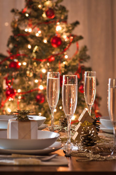 A Decorated Christmas Dining Table With Champagne Glasses