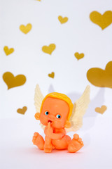 funny shy toy angel on background with hearts