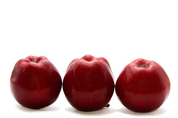 a row of three dark red apples