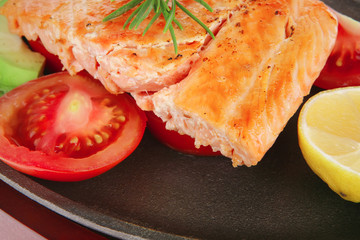 hot baked salmon piece served with vegetables