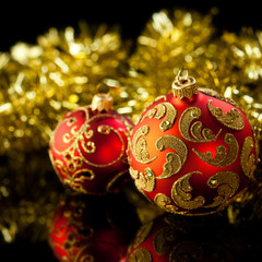 Red christmas balls and golden tinsel in background