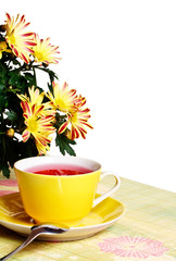 Cup of red tea and chrysanthemum flowers