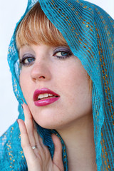 Portrait einer hübschen jungen blonden Frau mit einem blauen Kopftuch