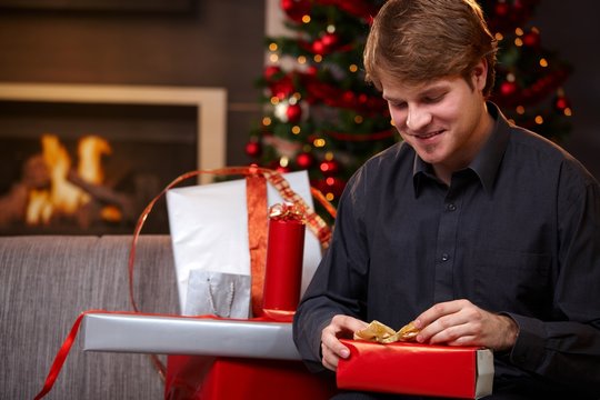 Young man wrapping presents at christmas