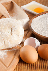 Fototapeta na wymiar Flour, raw eggs and dough for making bread