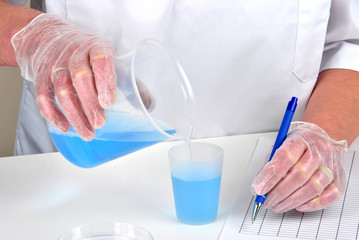 im Labor blaue Flüssigkeit umfüllen