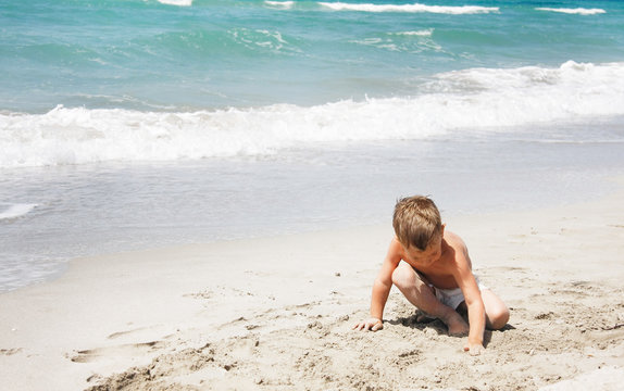 young boy playing on beach