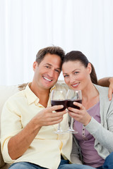 Lovely couple drinking red wine on the sofa