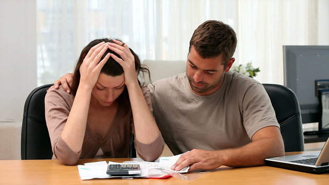 Man comforting her girlfriend while looking at their debts