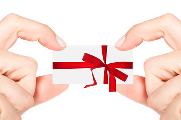 Female hands holding a small present with red ribbon isolated on