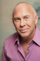 Headshot of a mature bald man smiling