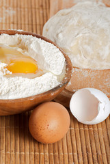 Flour, raw eggs and dough for making bread