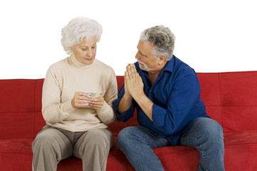 elderly couple on the couch with money in hand