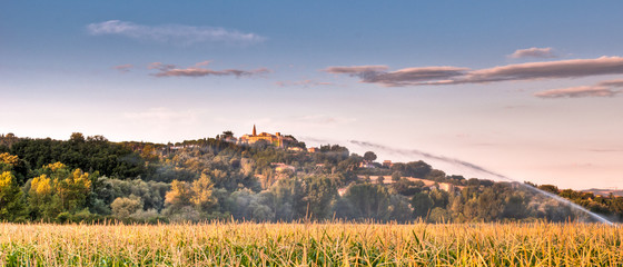Watering a field of maize near Italian hill top village