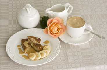 Banana cake with caramel sauce, and a cup of cappuccino