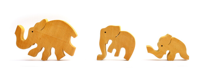 Three wooden toy elephants marching in a row