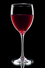 Glass of red wine over black background