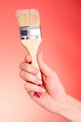 Hand with brush  on red background