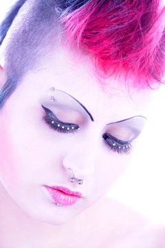 Eine Frau mit nachgemalten Augenbrauen und Wimpern mit Perlen
