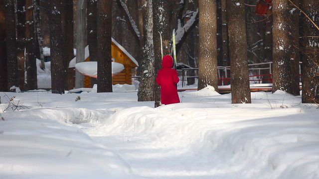 Girl with ski in winter park.