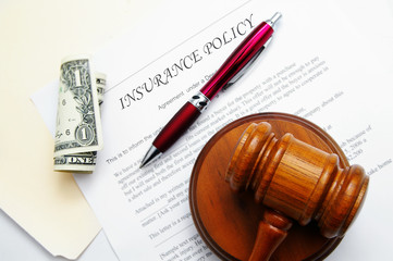 insurance policy with legal gavel and dollar bill