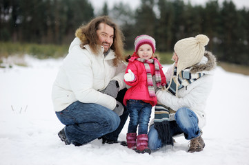 Happy family having fun on beautiful snowy winter day