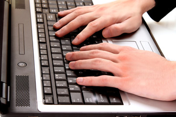 Male fingers typing a document on the black laptop