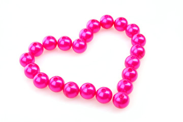 Heart from pink beads isolated on white background