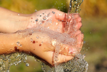 Fototapeta premium Woman's hands with water splash
