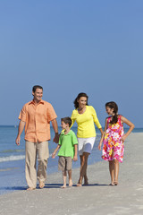 Mother, Father and Children Family Walking At Beach