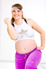 Smiling beautiful pregnant woman doing fitness exercises