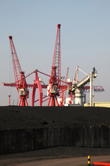 Fototapeta na wymiar Dock Cranes and Heap of Imported Coal at Avonmouth UK