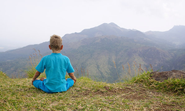 Photo of a boy meditating in mountain