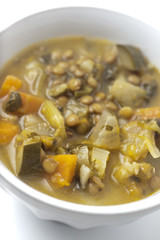 minestrone vegetariano in una scodella bianca su sfondo bianco
