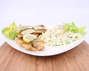 Fried fish with side salad decorated with lemon