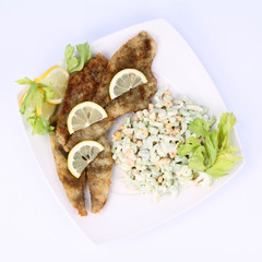 Fried fish with side salad decorated with lemon
