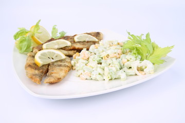 Fried fish with side salad decorated with lemon