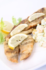 Fried fish with side salad decorated with lemon