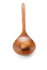 hazelnuts on a wooden spoon isolated on white