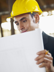 architect with blueprint in construction site