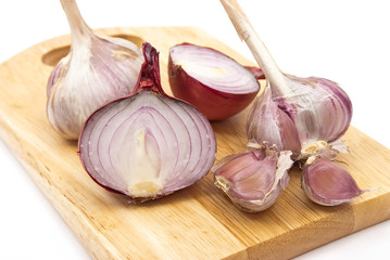 Garlic and onion on a wooden plate