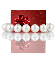 Pearls with creative red gift card, on a white background