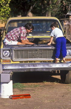 Father and son fixing truck.
