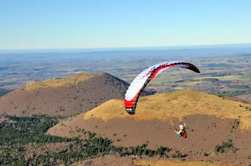 Foto op Plexiglas Paragliding above the chaine of volcanic hills © lophie