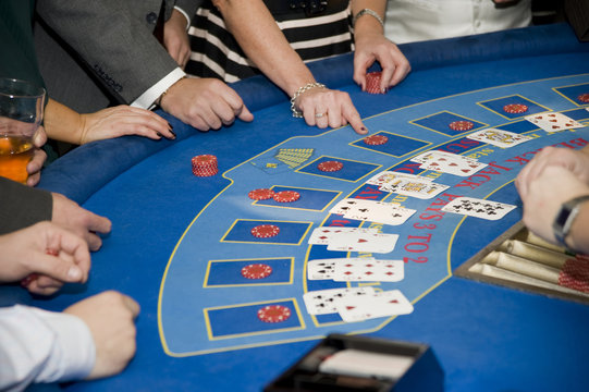 Image of men and women gambling playing blackjack