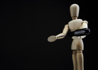 Wooden dool figure on black background.