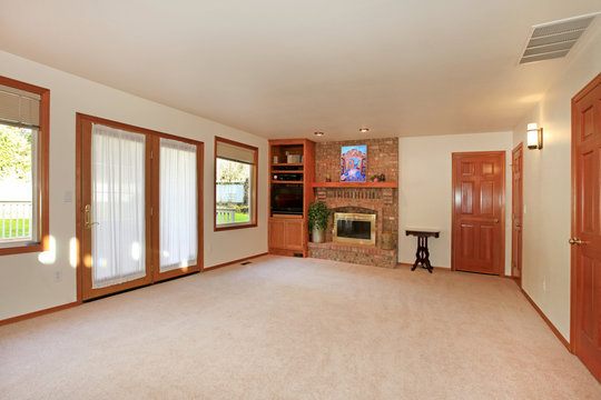 Empty living room with fireplace and doors