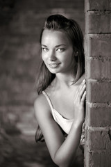 Fototapeta premium Beautiful woman near brick wall